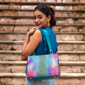 Woman posing with a colorful Anuschka Medium Everyday Tote - 710 over her shoulder, looking back over her shoulder on a stairway.