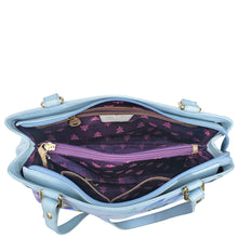 Load image into Gallery viewer, Light blue Anuschka genuine leather handbag with open interior showing purple lining and compartments.
