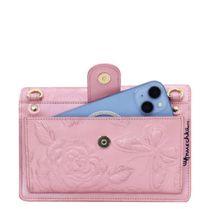 Pink Anuschka 4 in 1 Organizer Crossbody - 711 with embossed floral design and smartphone.