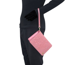 Load image into Gallery viewer, Person in a black outfit holding a pink Anuschka 4 in 1 Organizer Crossbody with RFID blocking.
