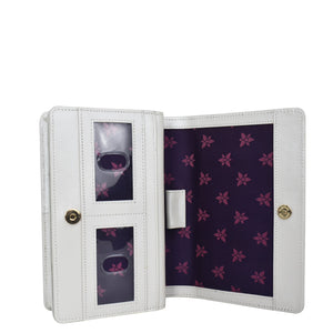 White Anuschka photo album with transparent pockets displaying photographs, featuring a floral purple interior design and crafted from genuine leather.