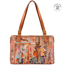 Load image into Gallery viewer, The Anuschka Expandable Shopper Tote - 712 is a genuine leather rectangular handbag featuring artistic Egyptian-themed designs, brown straps, and a &quot;Vegetable Tanned Genuine Leather&quot; stamp in the top right corner. It offers ample space and functionality without compromising on style.
