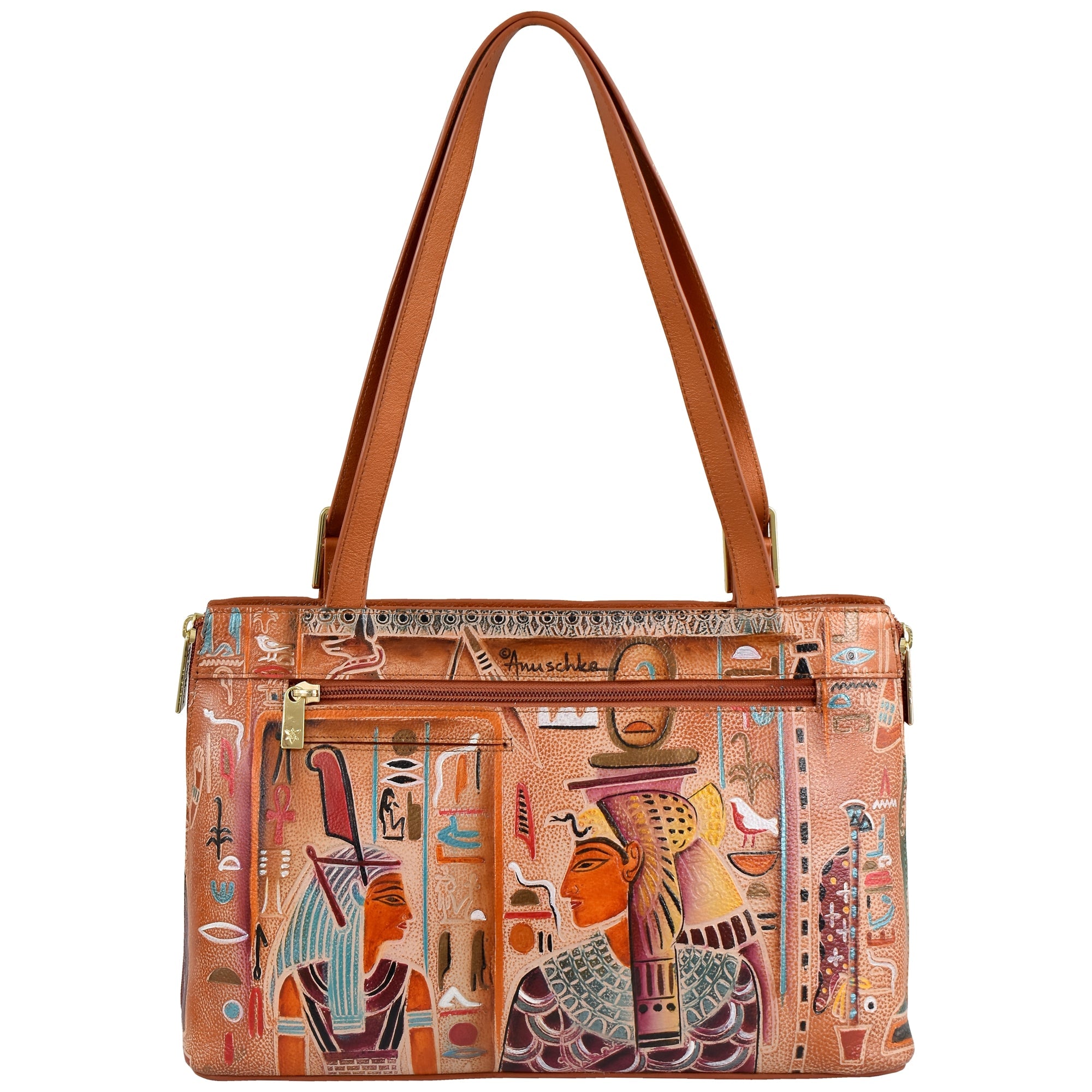 The Expandable Shopper Tote - 712 by Anuschka is a spacious handbag crafted from genuine tan leather. It features two handles and is adorned with hand-painted Egyptian artwork depicting historical figures and vibrant symbols. Complete with a front zipper pocket and gold hardware, it effortlessly blends style and convenience.