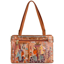 Load image into Gallery viewer, The Expandable Shopper Tote - 712 by Anuschka is a spacious handbag crafted from genuine tan leather. It features two handles and is adorned with hand-painted Egyptian artwork depicting historical figures and vibrant symbols. Complete with a front zipper pocket and gold hardware, it effortlessly blends style and convenience.
