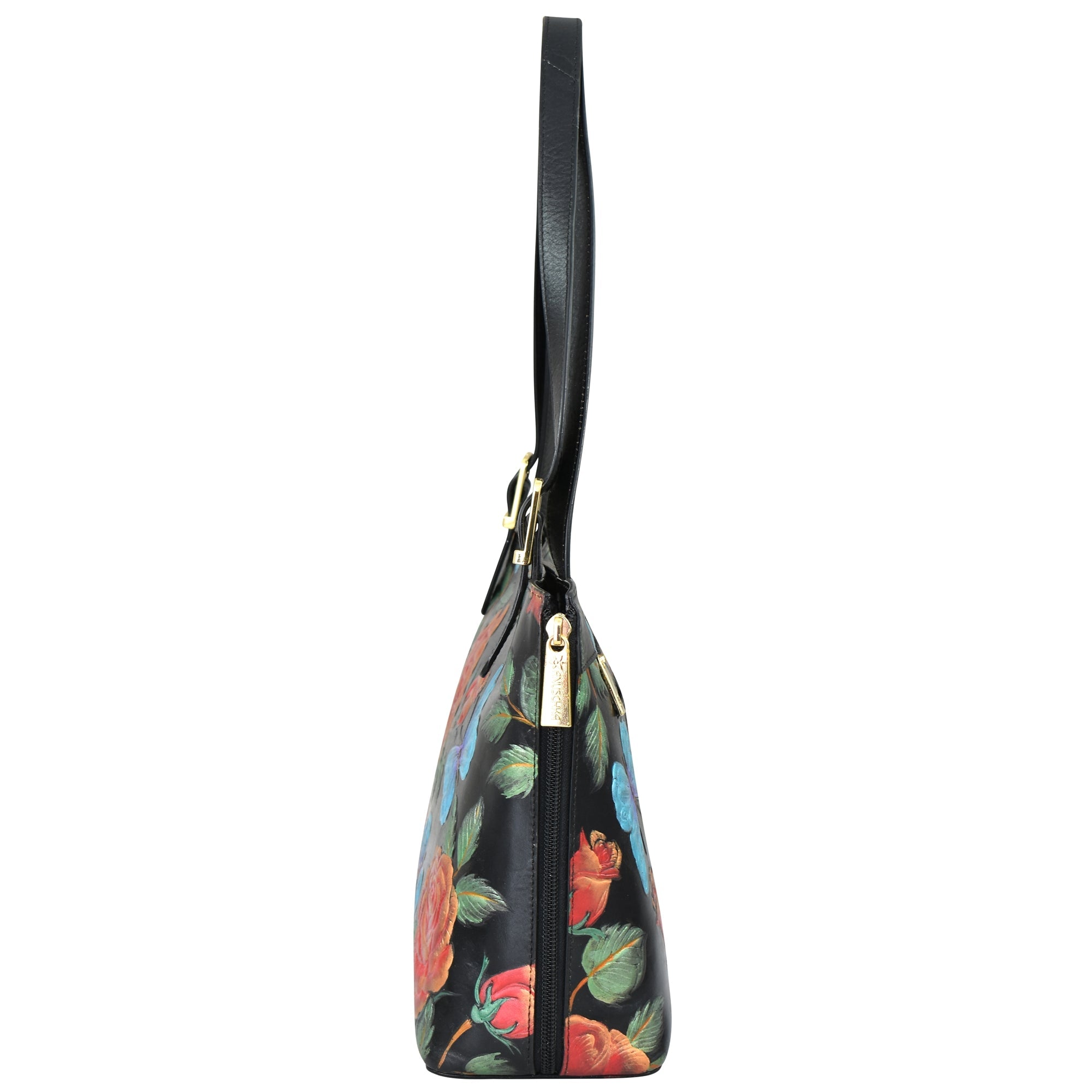 Side view of the Expandable Shopper Tote - 712 by Anuschka, a black genuine leather tote adorned with a floral pattern featuring red, blue, and green flowers, complete with a top handle and a gold zipper.