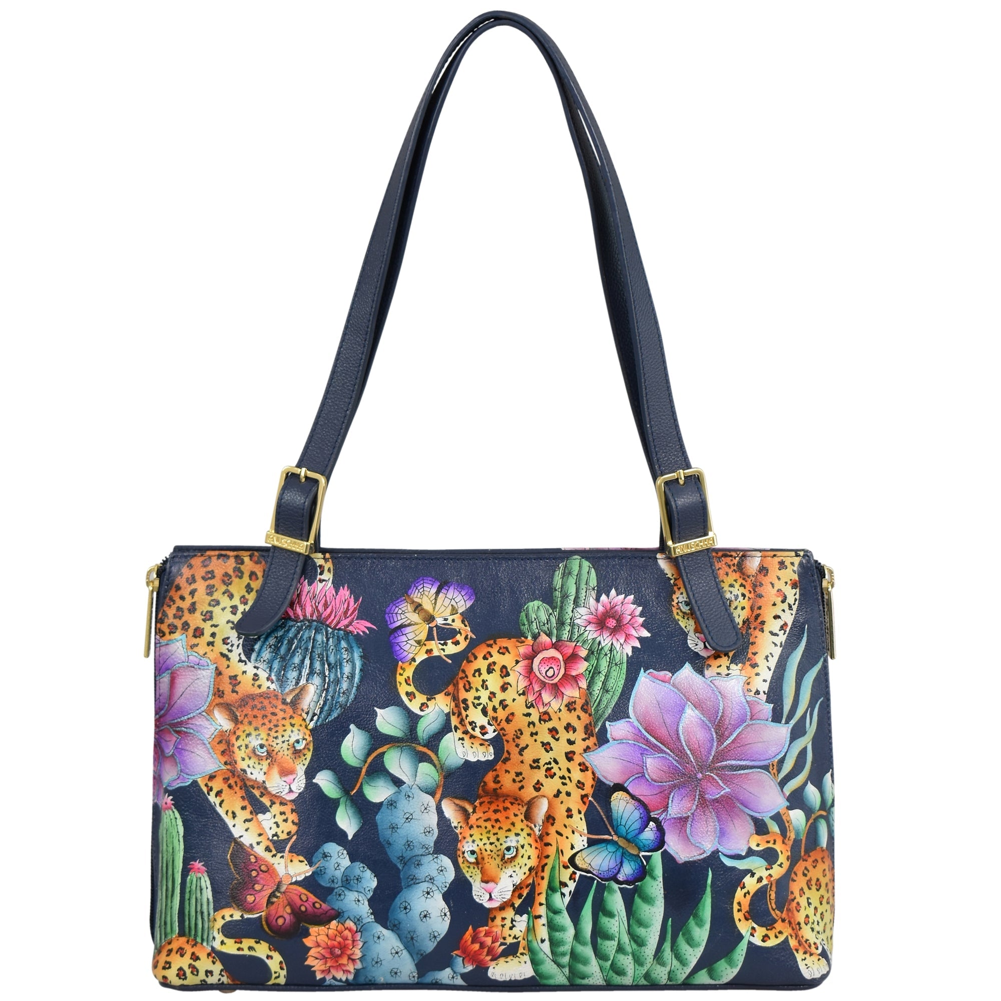 The Anuschka Expandable Shopper Tote - 712 is a genuine leather tote with dark straps that features a vibrant design of leopards, flowers, cactus plants, and a butterfly against a black background.