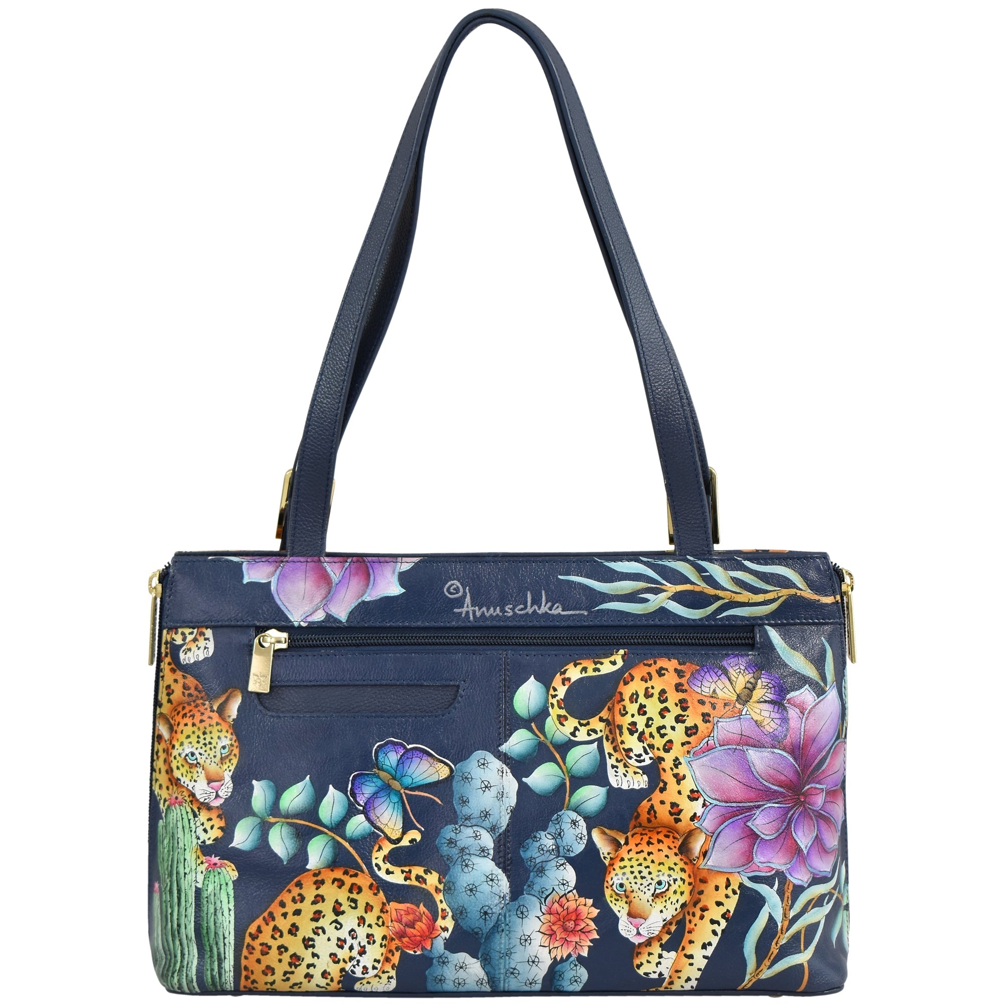 The Anuschka Expandable Shopper Tote - 712 is a navy blue handbag featuring two shoulder straps and adorned with a vibrant design of leopards, flowers, and a butterfly. This genuine leather tote masterfully combines elegance with durability.