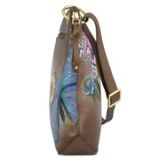 Side view of the Anuschka Crossbody Sling Bag - 713 showcasing genuine leather adorned with vibrant floral and butterfly hand painted artwork, complemented by gold-tone hardware and an adjustable crossbody strap.