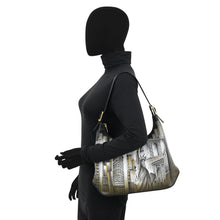 Load image into Gallery viewer, Faceless mannequin wearing a black turtleneck and holding the Anuschka Slim Shoulder Hobo - 714, featuring a genuine leather architectural and statue design.
