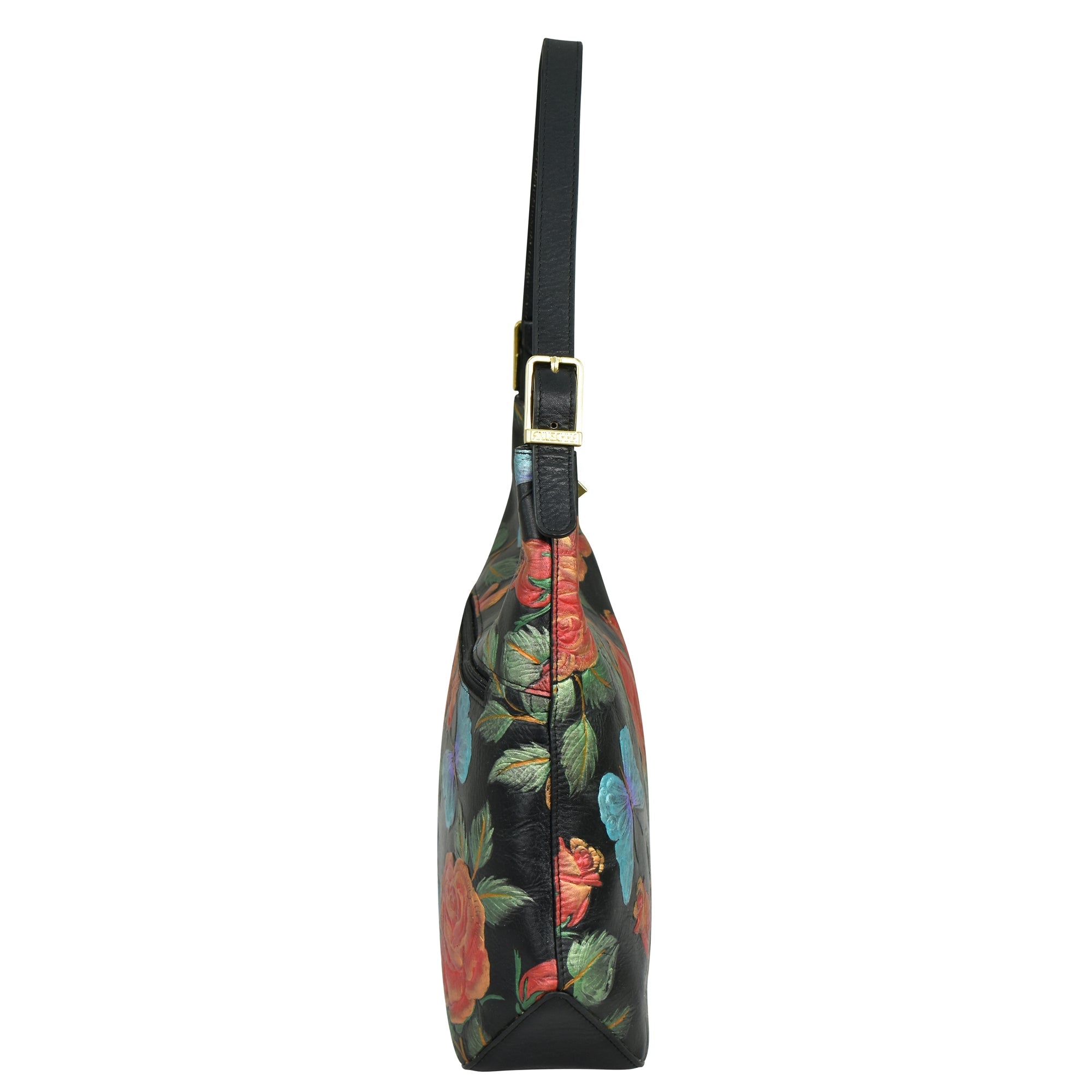 Side view of the Anuschka Slim Shoulder Hobo - 714 in black genuine leather with a colorful floral design, featuring a gold buckle on the adjustable strap and visible stitching.