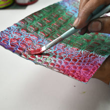 Load image into Gallery viewer, Hand painting red color onto a textured, multicolored Anuschka Medium Everyday Tote - 710.
