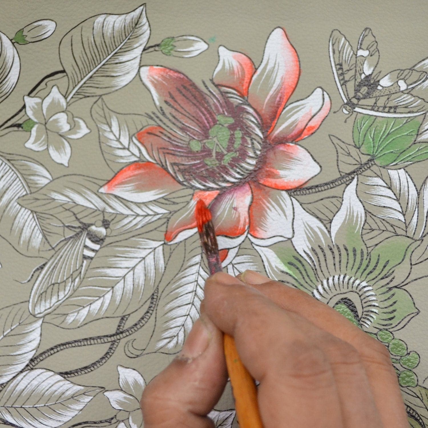 A detailed floral artwork with hand-painted flowers in red and green shades on the Expandable Shopper Tote - 712 by Anuschka, held by someone using a brush.