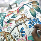 A close-up view of an Anuschka Zip Around Travel Organizer - 668 handbag with a colorful leopard and floral print design, crafted from leather.