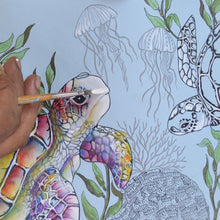 Load image into Gallery viewer, An artist&#39;s hand painting a colorful sea turtle on an Anuschka 4 in 1 Organizer Crossbody - 711 mural with jellyfish and coral details.

