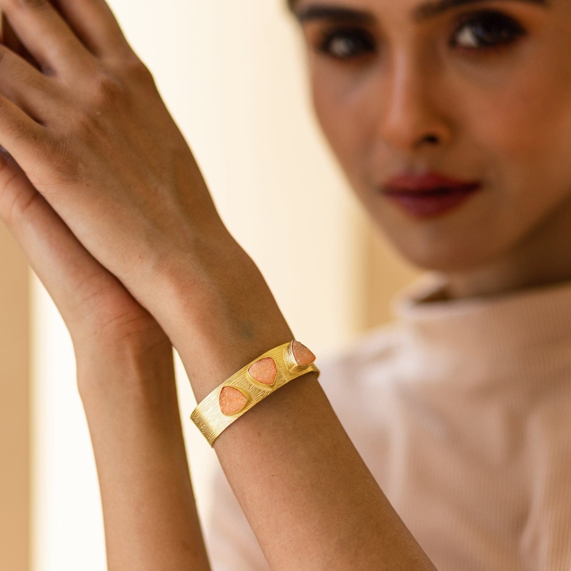 Woman showcasing a Vanya Lara Triangle Druzy Bracelet - VBR0002 with a unique texture and inlaid gemstones.