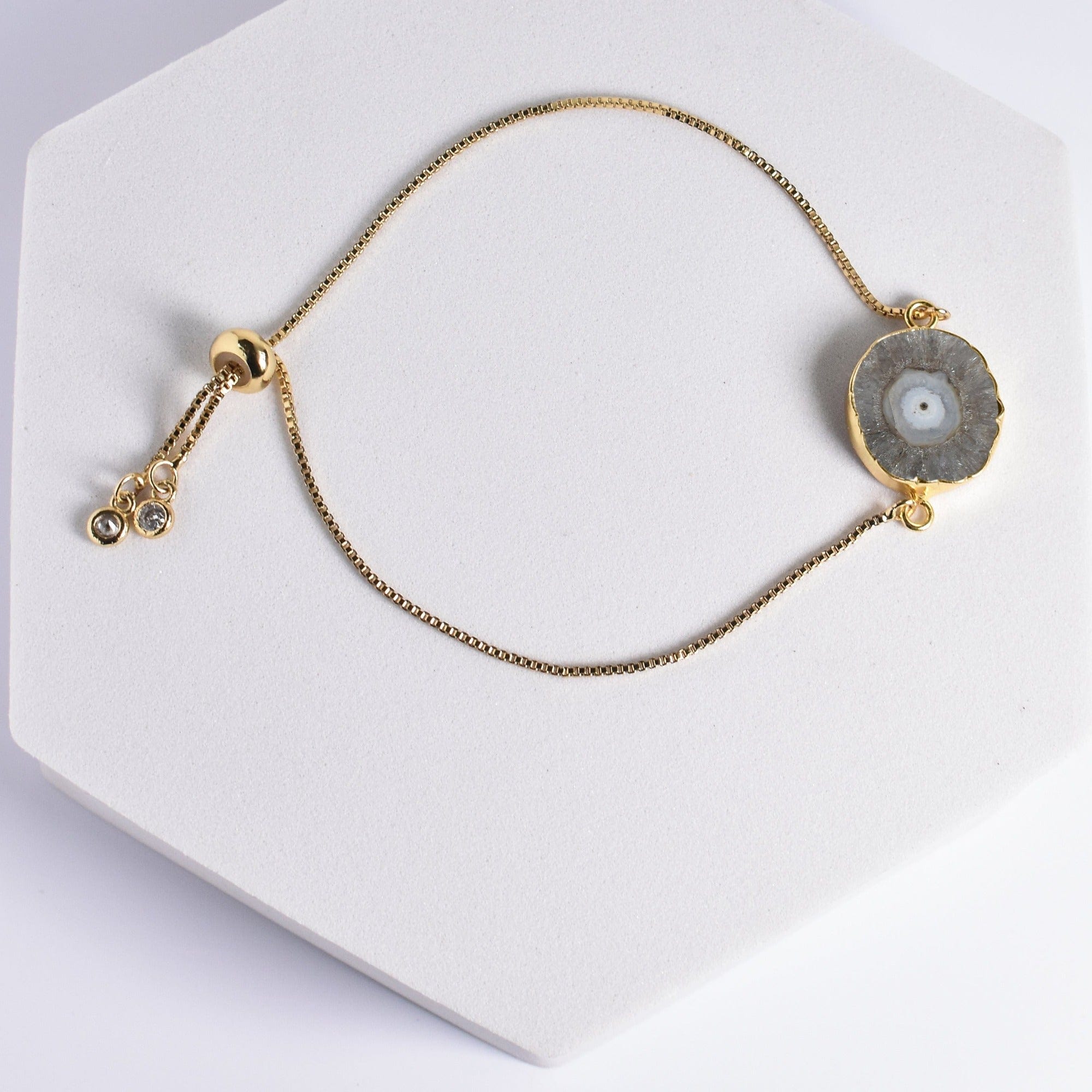 Gold-plated necklace with a Sliced Quartz Bracelet pendant on a white display stand by Vanya Lara.