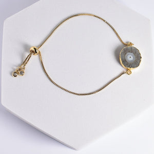 Gold-plated necklace with a Sliced Quartz Bracelet pendant on a white display stand by Vanya Lara.