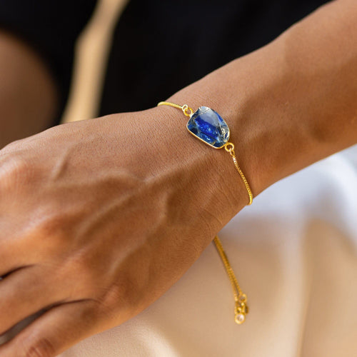 A woman's wrist adorned with a delicate gold chain Mojave Glory Bracelet from her Vanya Lara jewelry collection, featuring a large Mojave stone centerpiece.