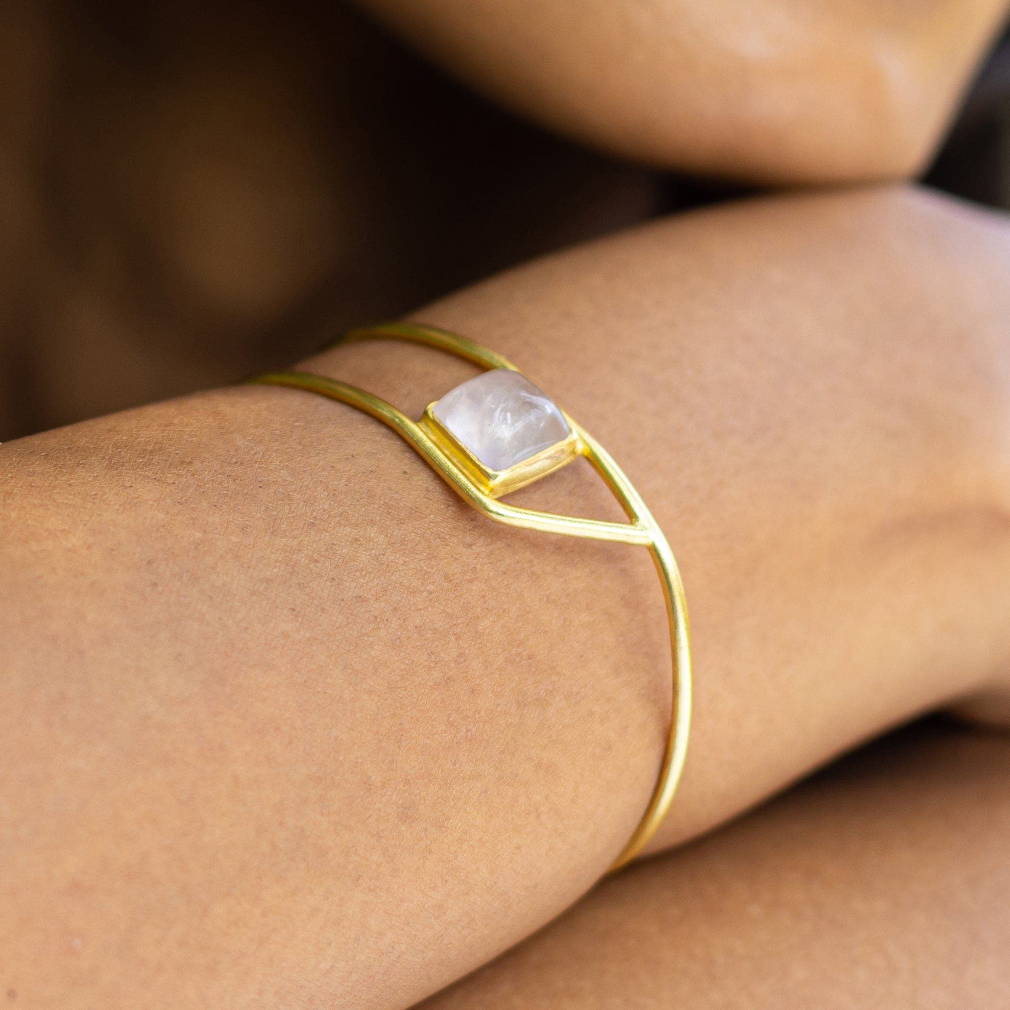 A close-up of a Golden Ratio Bracelet - VBR0006 from Vanya Lara with a single natural gemstone, worn on a wrist.