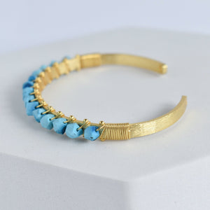 Trillion Cut Gemstone Bangle with blue gemstone embellishments by Vanya Lara.
