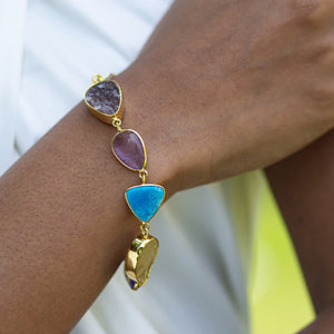 A person wearing an Enchanting Melody Bracelet by Vanya Lara with multicolored natural gemstones.