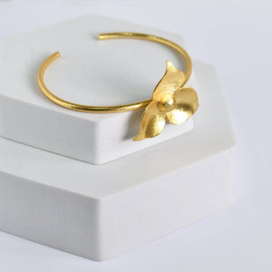 Golden Flower Bracelet by Vanya Lara, showcasing exquisite craftsmanship, on a white display box.