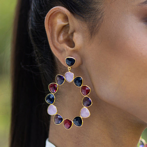 A woman wearing Vanya Lara's Kaleidoscope Eternity Earrings with multicolored natural gemstones.