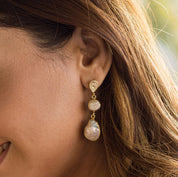 A woman showcasing a pair of Pearl of Joy Earrings by Vanya Lara, gold-plated teardrop earrings with fresh water pearls.