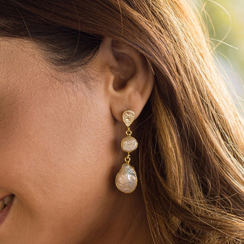 A woman showcasing a pair of Pearl of Joy Earrings by Vanya Lara, gold-plated teardrop earrings with fresh water pearls.
