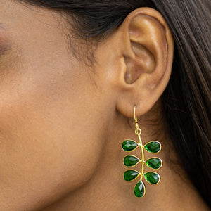 A woman wearing Vanya Lara's Foliage Earrings (VER0005) with an eye-catching, green gemstone design.