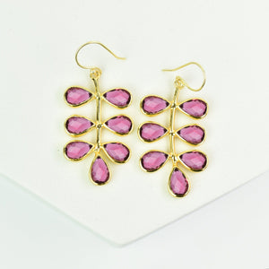 Foliage Earrings by Vanya Lara with pink gemstones arranged in a floral nature pattern on a white display stand.