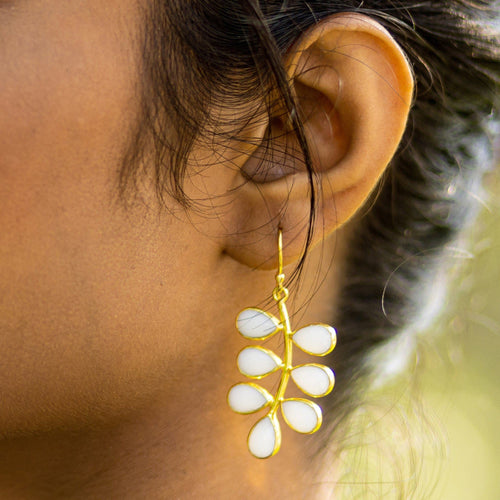 Close-up of a woman's ear wearing a Foliage Earrings - VER0005 by Vanya Lara, featuring an eye-catching hydro quartz floral design.