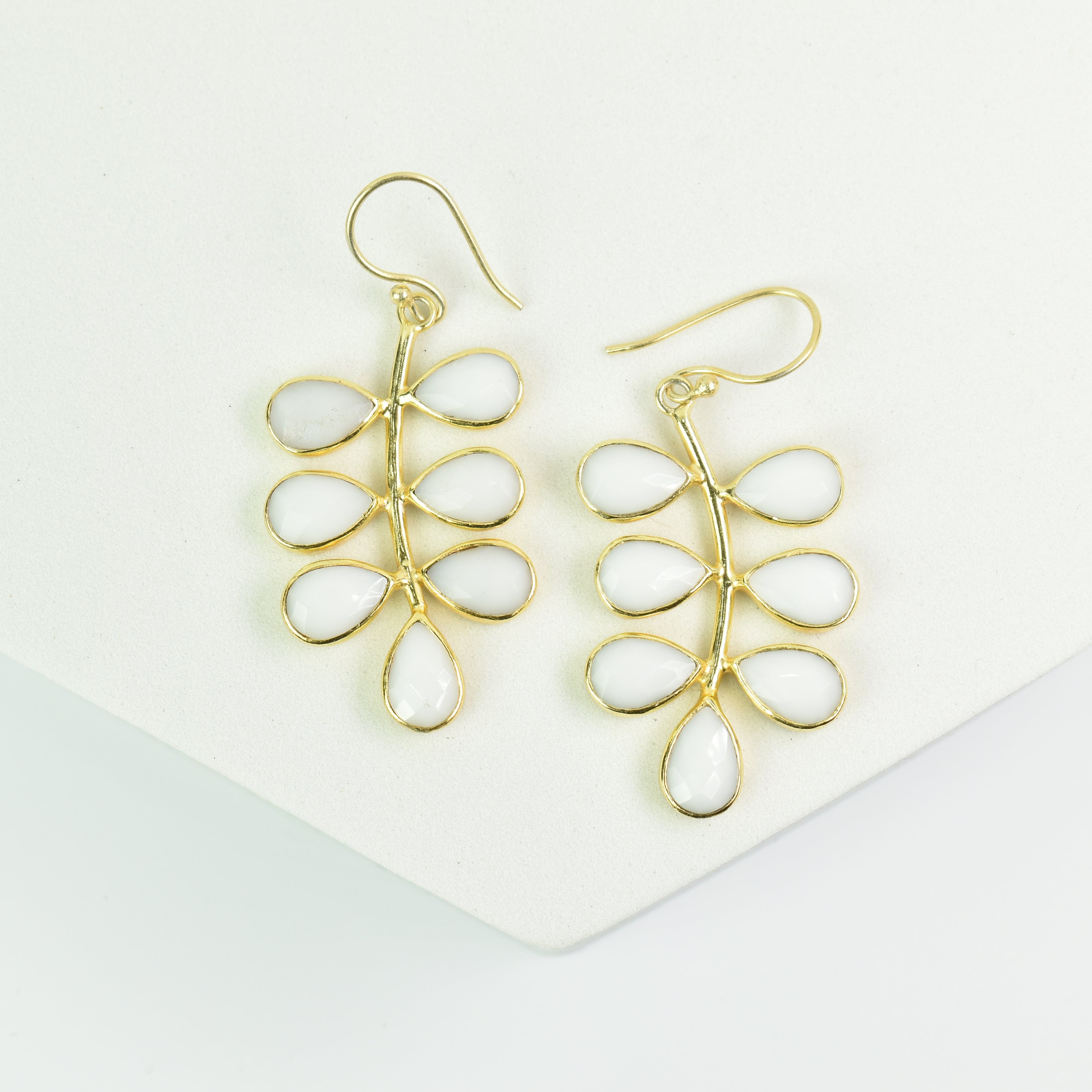 A pair of Foliage Earrings - VER0005 by Vanya Lara, featuring gold-plated and white teardrop-shaped dangle earrings with a unique design, displayed against a white background.