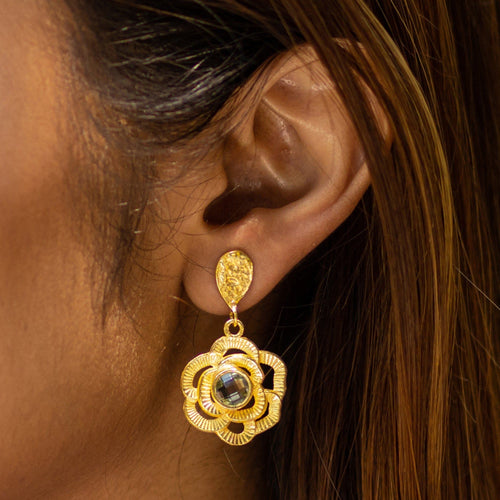 Close-up of a woman's ear wearing a Vanya Lara Floral Drop Earrings (VER0007) with 22k gold petals.