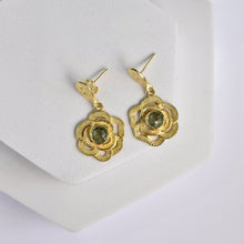 Load image into Gallery viewer, Floral Drop Earrings with hydro stone centers displayed on a white stand by Vanya Lara.

