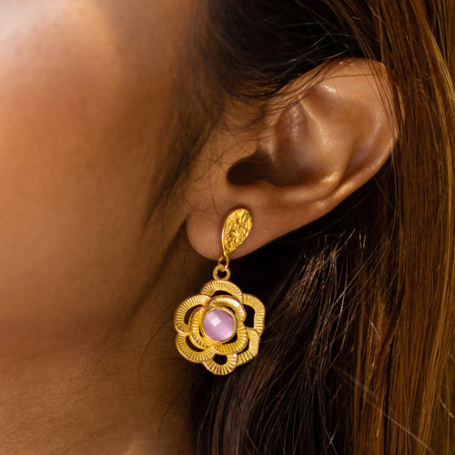 A close-up of a woman's ear wearing a Vanya Lara Floral Drop Earrings - VER0007 with hydro stone petals.