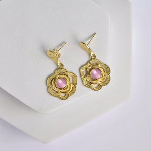 Vanya Lara Gold-tone Floral Drop Earrings with Pink Hydro Stone Centers displayed on a white stand.