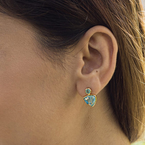Close-up of a woman's ear wearing a Vanya Lara turquoise triangle drop stud earring (VER0009).