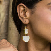 A close-up of a woman wearing Two-Tiered Geometric Earrings by Vanya Lara with Sugar Druzy stones.