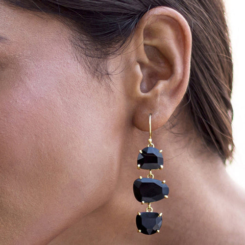 A woman wearing Vanya Lara's Long Triple Drop Earrings with three black natural stones.