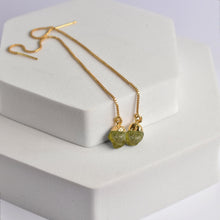 Load image into Gallery viewer, Pendulum Thread Earrings with green gemstone beads on a white display block by Vanya Lara.
