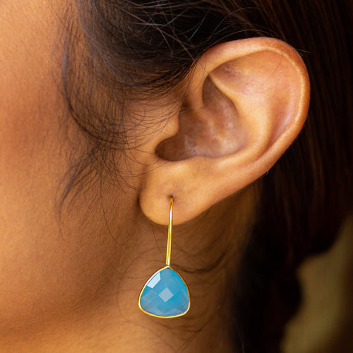 A close-up of a woman's ear wearing Vanya Lara's Beyond The Dainty Earrings - VER0014 with a large hydro quartz gemstone.