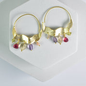 Crescent Moon Hoops Earrings with bird designs and dangling Hydro Quartz gemstones on a white surface by Vanya Lara.