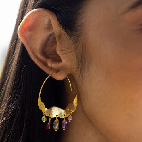 A woman's profile showcasing an ornate Crescent Moon Hoops Earrings with colored Hydro Quartz gemstones by Vanya Lara.