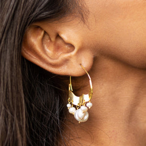 Crescent Moon Hoops Earrings by Vanya Lara, worn on a person's ear.