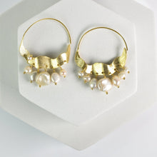 Load image into Gallery viewer, Crescent Moon Hoops Earrings adorned with pearls and small gold accents, displayed on a white surface by Vanya Lara.

