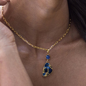 A close-up of a person wearing a Vanya Lara Mojave Drop Necklace - VNK0003 with a turquoise stone pendant.