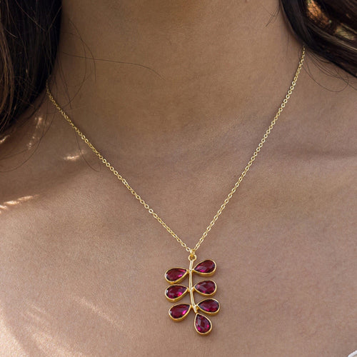 Woman wearing a Vanya Lara foliage necklace with a red hydro quartz pendant.