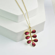 Foliage Necklace by Vanya Lara with a leaf-shaped pendant featuring red hydro quartz gemstones on a white background.