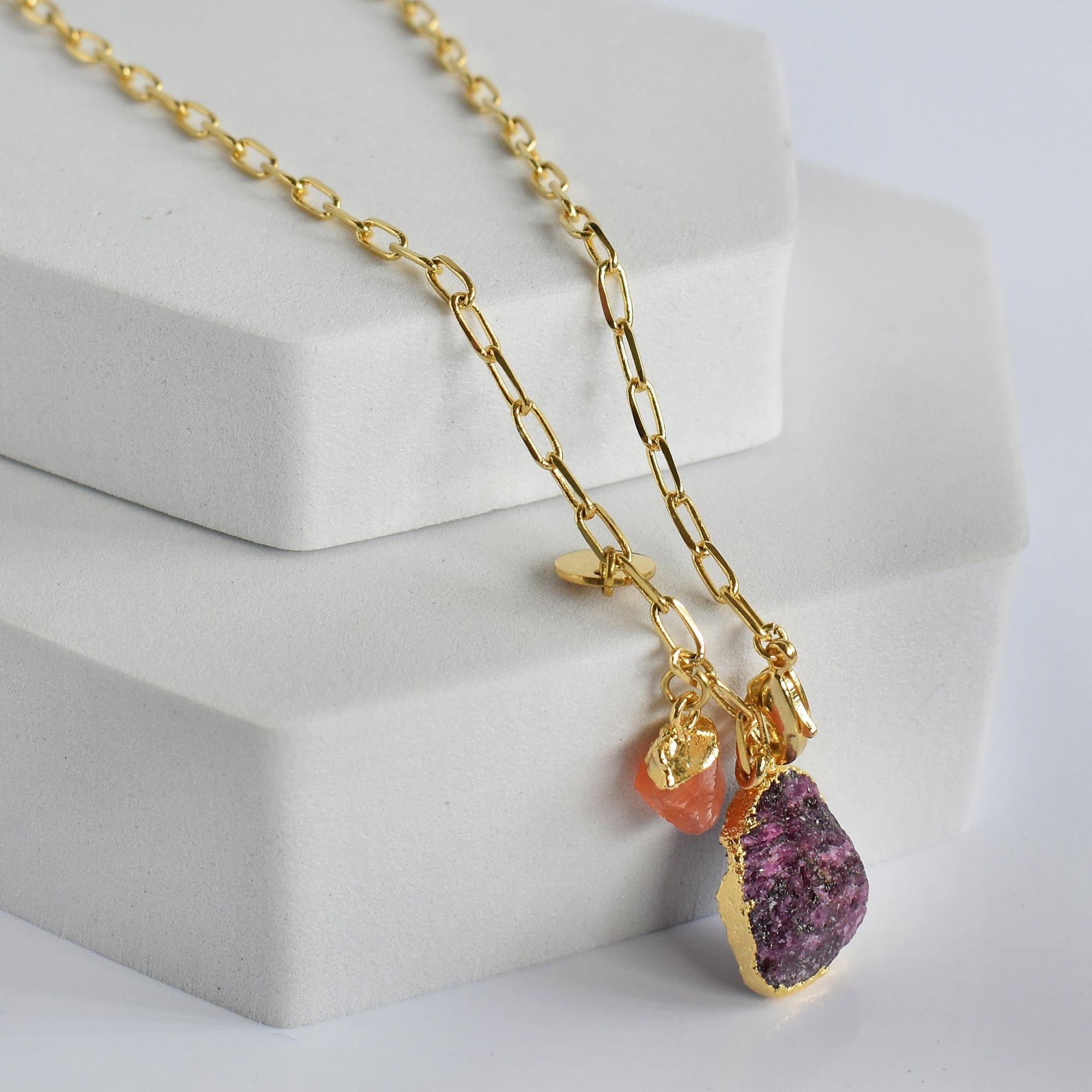 A woman wearing a pink top and a 22K gold-plated necklace with an Abstract Gemstone Pendant (VNK0005) from Vanya Lara.